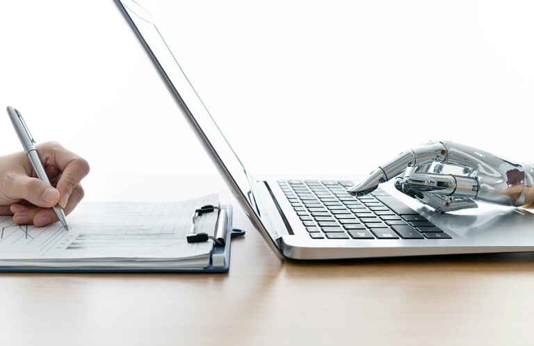 Robot hand using laptop and man hand writing stock photo