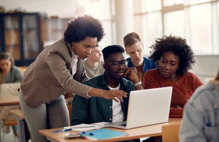 College students and their teacher use laptop during computer class