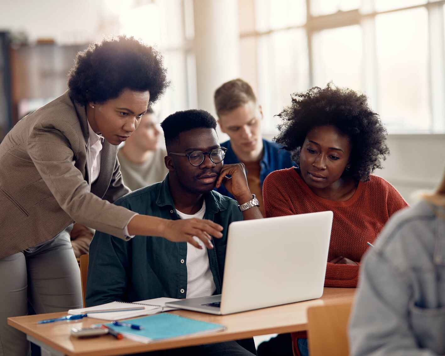 College students and their teacher use laptop during computer class