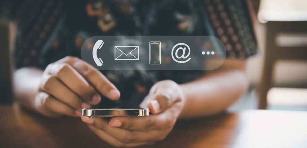 Photo of a woman using her mobile phone with icons for phone, email, etcetera overlayed