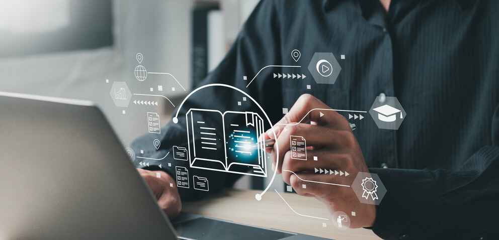 Close up photo of a person working on a laptop with educational technology images floating in the air
