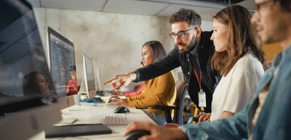 Lecturer Helps Scholar with Project, Advising on Their Work. Teacher Giving Lesson to Diverse Multiethnic Group of Female and Male Students in College, Teaching Computer Science and Writing Code.